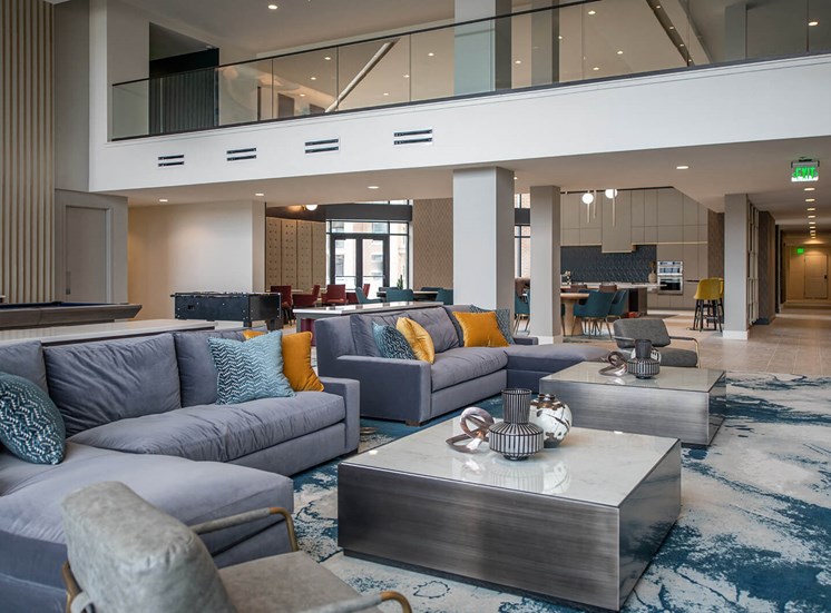 two groups of gray couches around square coffee tables in an indoor atrium room